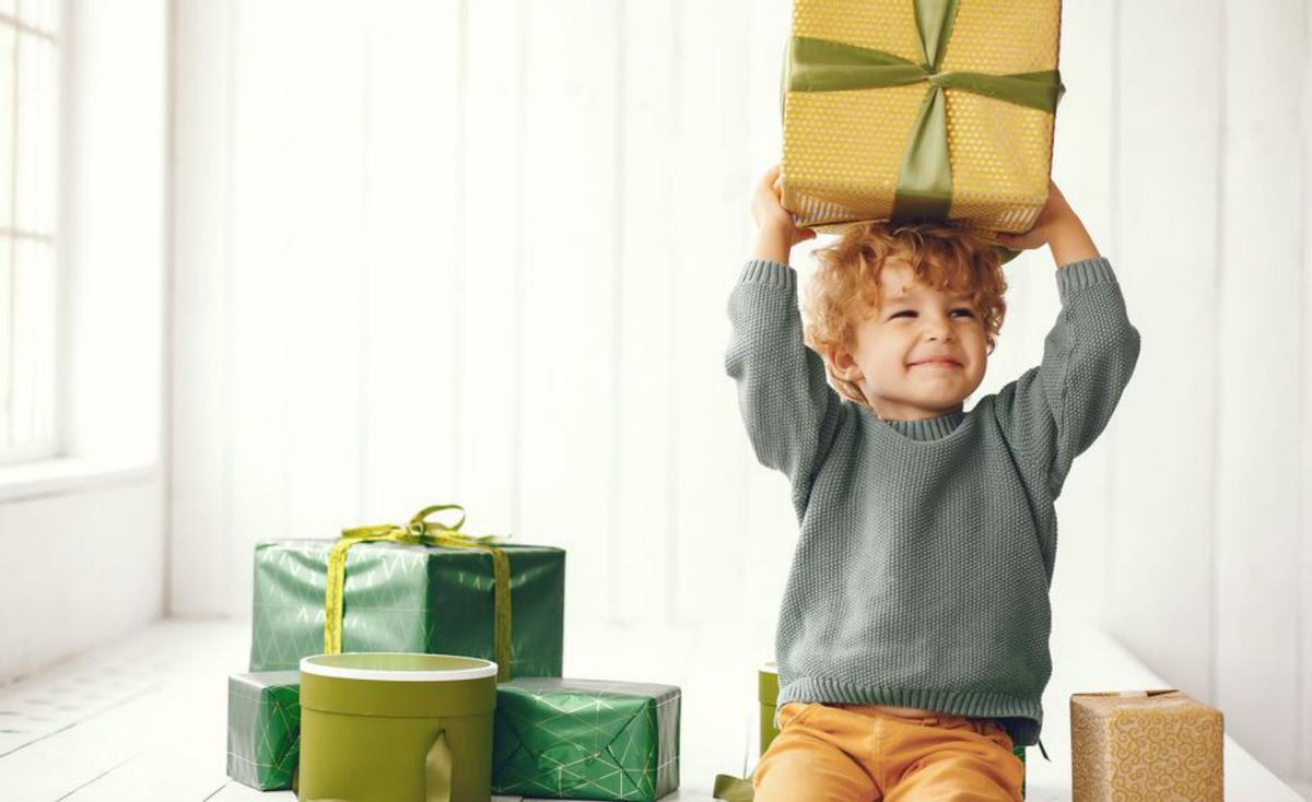 Un niño con muchos regalos. |  | FREEPIK