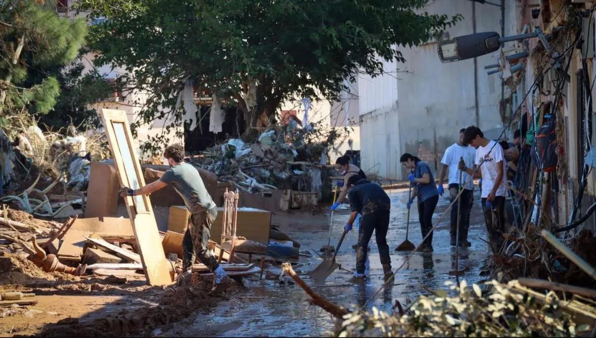 Vecinos de Torrent sacando enseres de sus casas días depsués de la dana.
