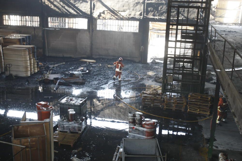 Los bomberos trabajan en la nave de ataúdes siniestrada hoy en Moixent.