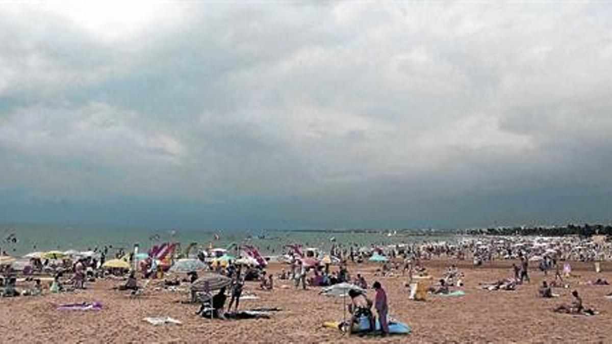 Bañistas bajo un cielo nublado en la playa de Salou, el pasado viernes.