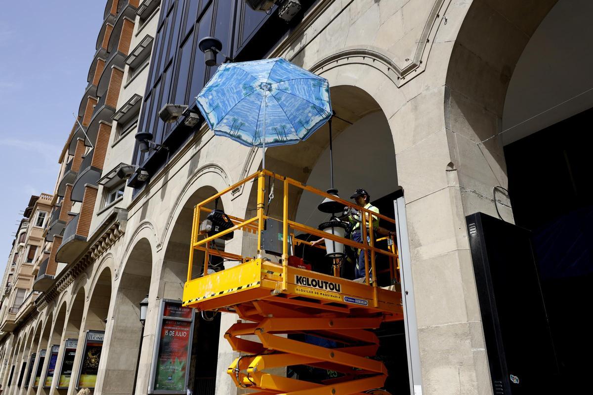 Los trabajadores utilizan sombrillas para protegerse del sol.