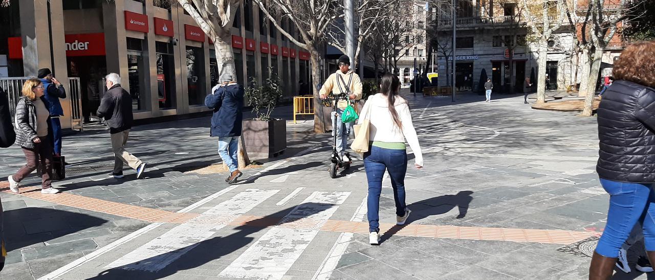 Un patinete circula por la plaza de España circula entre peatones.