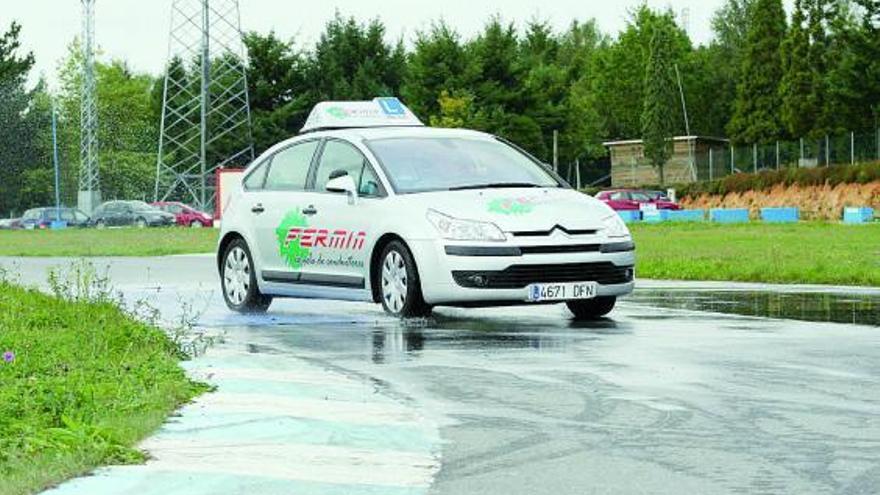 Un vehículo de autoescuela realiza prácticas en una pista cerrada.