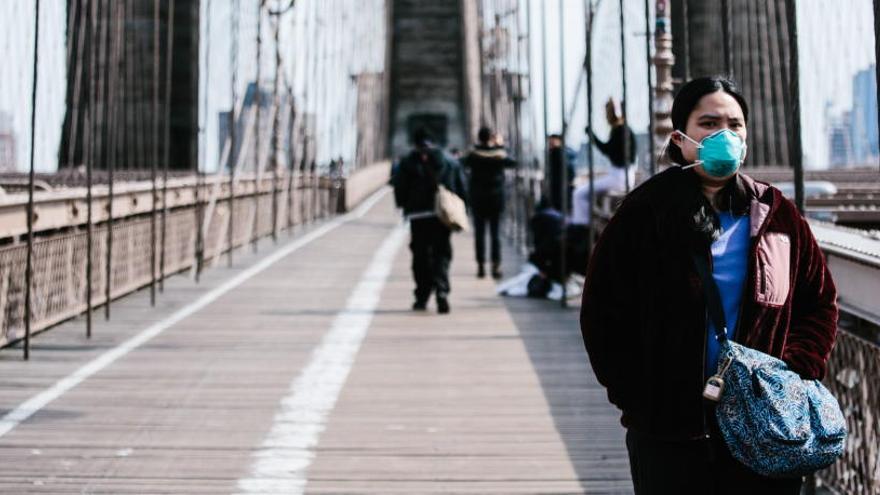 Una mujer camina por el puente de Brooklyn.