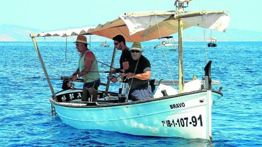Tres vecinos y amigos de Formentera, fieles a la pesca del ´raor´ recuperan sedal, a lo largo de la Torre de sa Gavina.