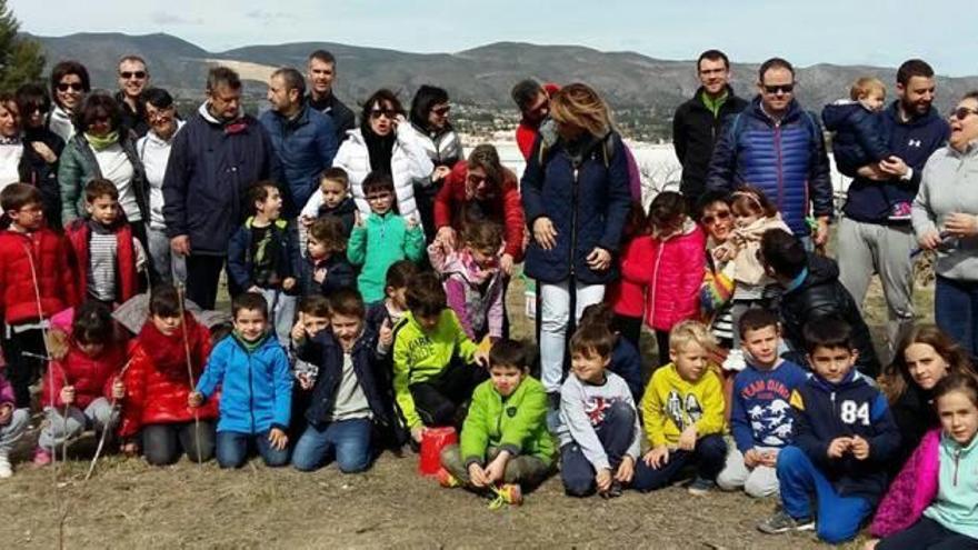 Los escolares, sus padres y los técnicos del consistorio ontinyentino, el sábado tras la plantación realizada en la Casa Balones.