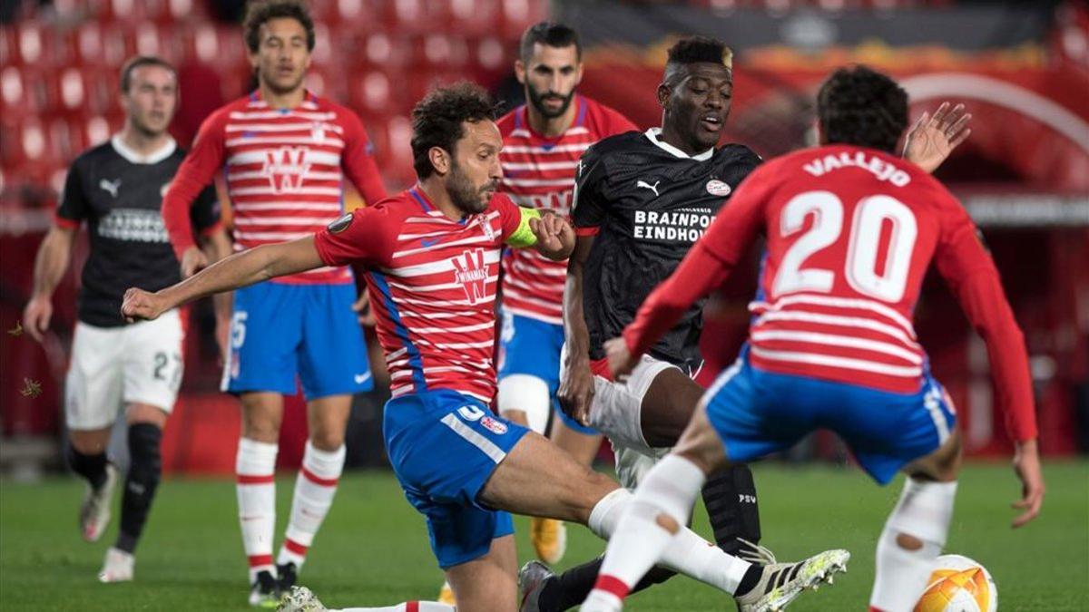 El central del Granada Germán pugna por un balón con un rival