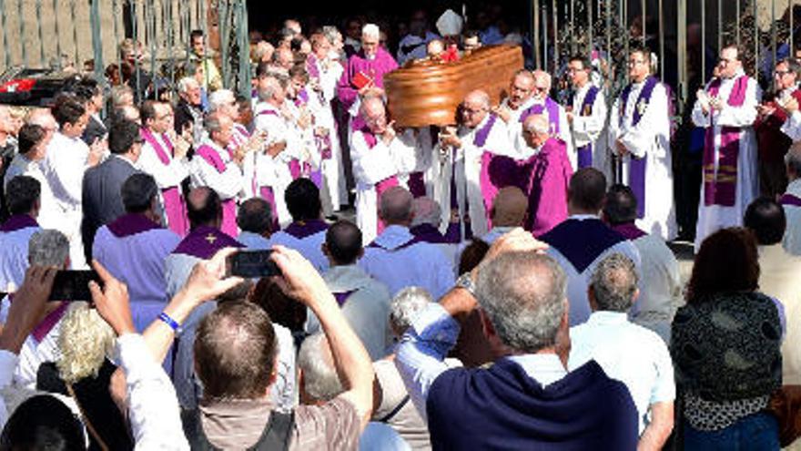 El féretro con los restos mortales de Policarpo Delgado sale de la Catedral de Santa Ana a hombros de un grupo de sacerdotes entre aplausos de compañeros y vecinos.