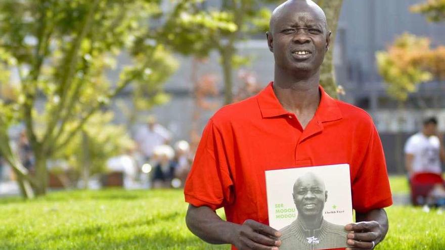 Cheikh Fayé, co seu libro &#039;Ser Modou Modou&#039;, no barrio das Conchiñas, no que reside.