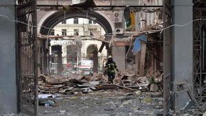 Un bombero camina entre los escombros de un edificio bombardeado por las fuerzas rusas en la plaza de la Constitución, en Járkov.