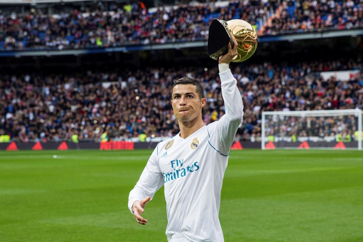 El delantero portugués del Real Madrid Cristiano Ronaldo muestra el trofeo del Balón de Oro en el estadio Santiago Bernabéu.