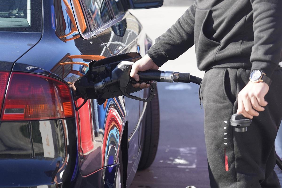 Una persona omplint el dipòsit a una benzinera de Girona.