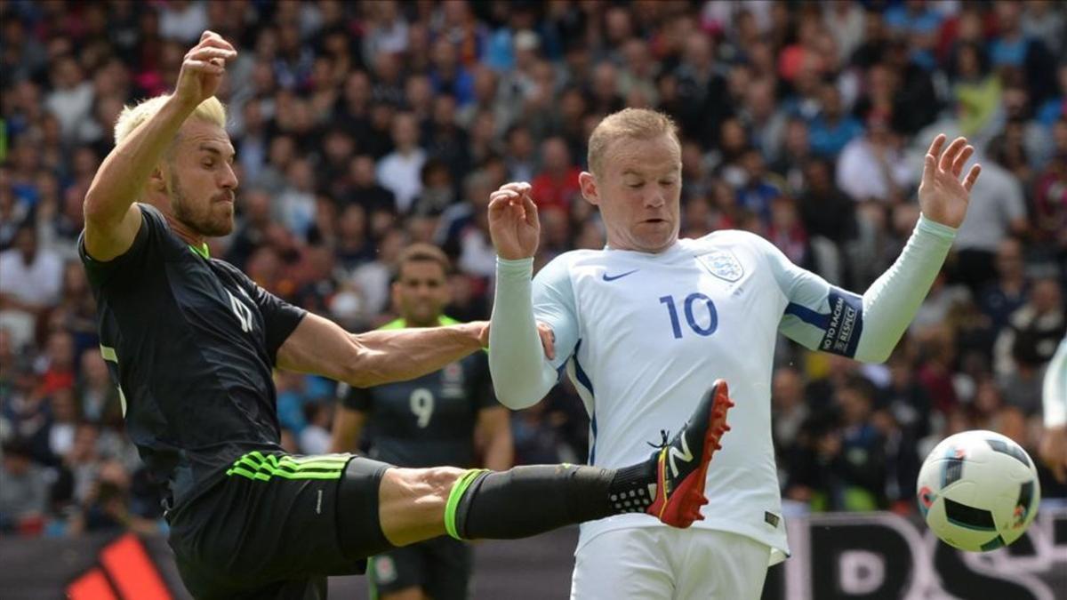 Wayne Rooney pelea un balón con el galés Ramsey durante la pasada Eurocopa de Francia
