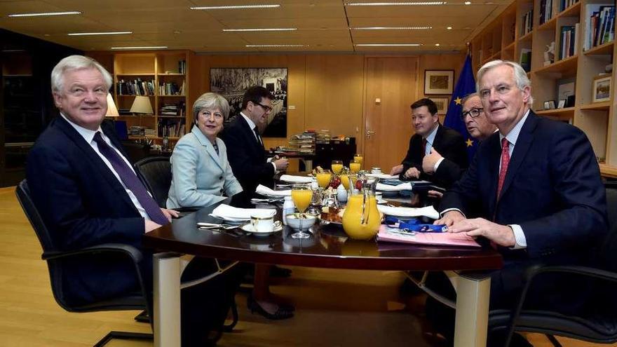 El ministro británico para el &quot;Brexit, David Davis, y May (izq.), frente a Juncker y el negociador de la UE, Michel Barnier, ayer en Bruselas, durante la negociación. // Reuters