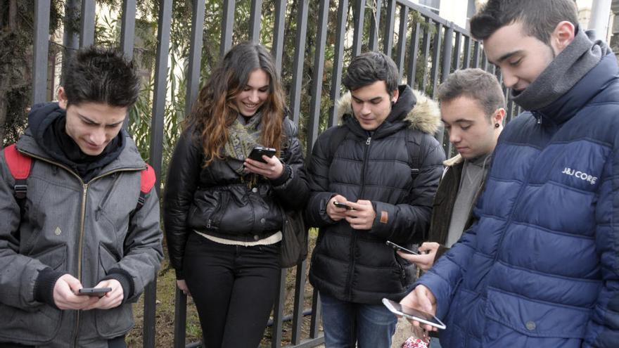 Un grup de joves utilitzant els seus telèfons mòbils.