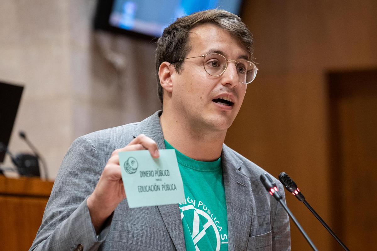 Jorge Pueyo durante si intervención mostrando un cartel en favor de la educación pública.