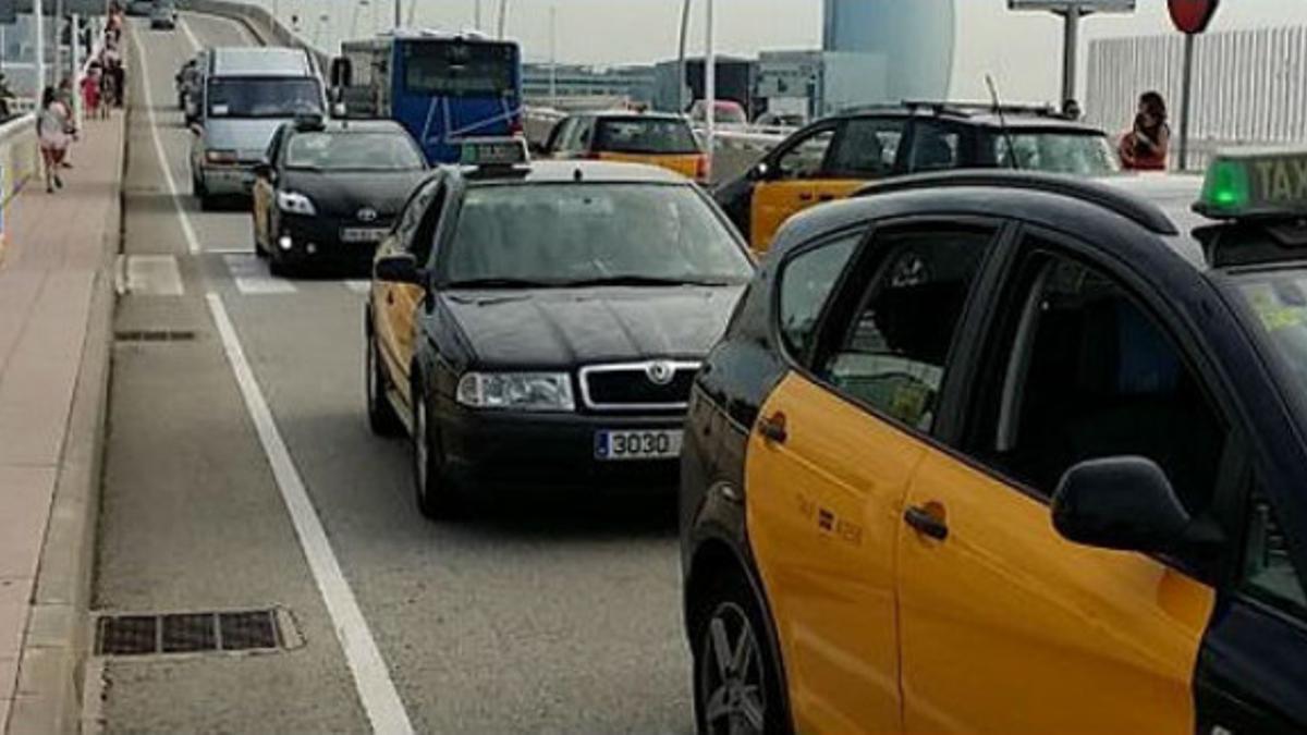 Marcha lenta de taxistas, concentrados, en el puerto de Barcelona.