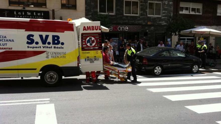 Una ambulancia se lleva al único herido. La policía, mientras, revisa el coche ante los testigos.