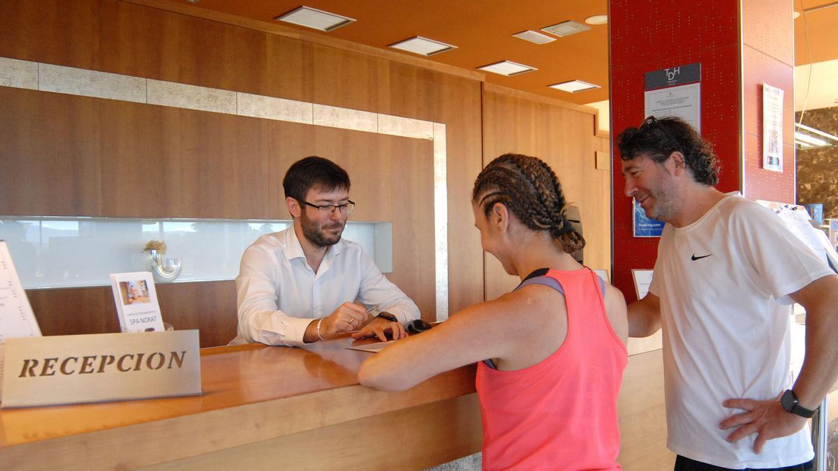 Clientes haciendo el registro de llegada en el hotel Torre do Deza de Lalín.