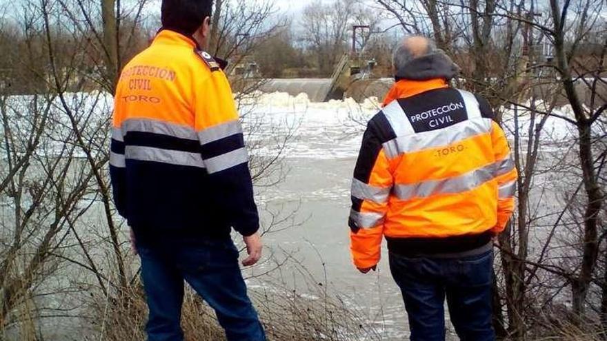 Dos voluntarios en la presa de Timulos.