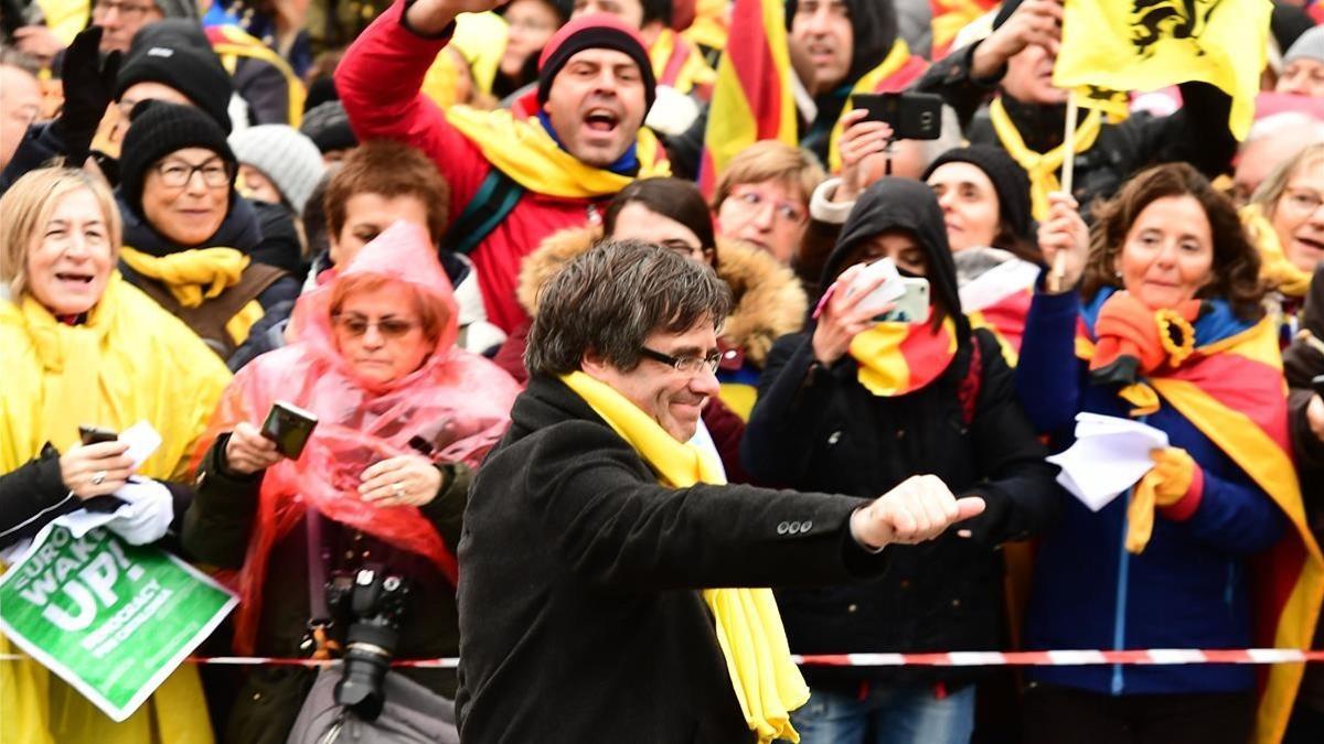 El expresidente Carles Puigdemont saluda a la multitud congregada en Bruselas.