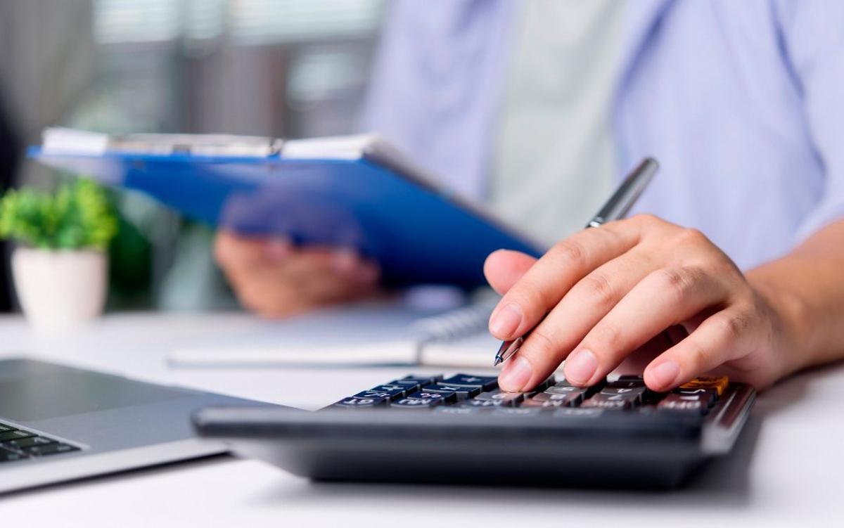 Imagen genérica de un empleado de recursos humanos calculando y revisando una nómina.