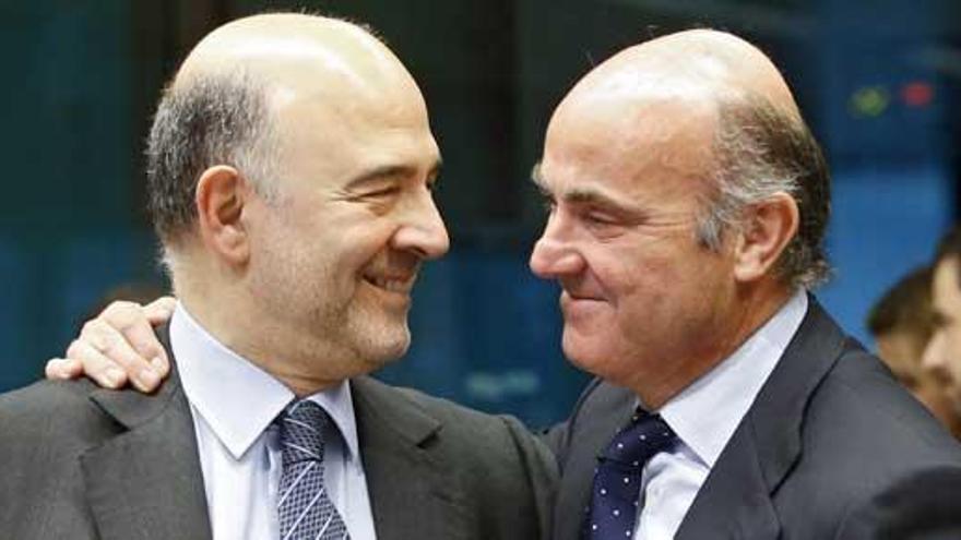 Guindos, con el comisario europeo de Economía, Moscovici.