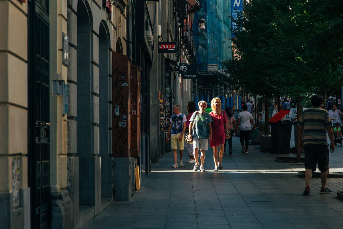 Una pareja baja la calle de Carretas hacia la Puerta del Sol, en Madrid.