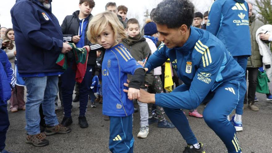 A la izquierda, Costas firma una camiseta a un joven aficionado. Abajo, varios aficionados,  en El Requexón.  | MIKI LÓPEZ