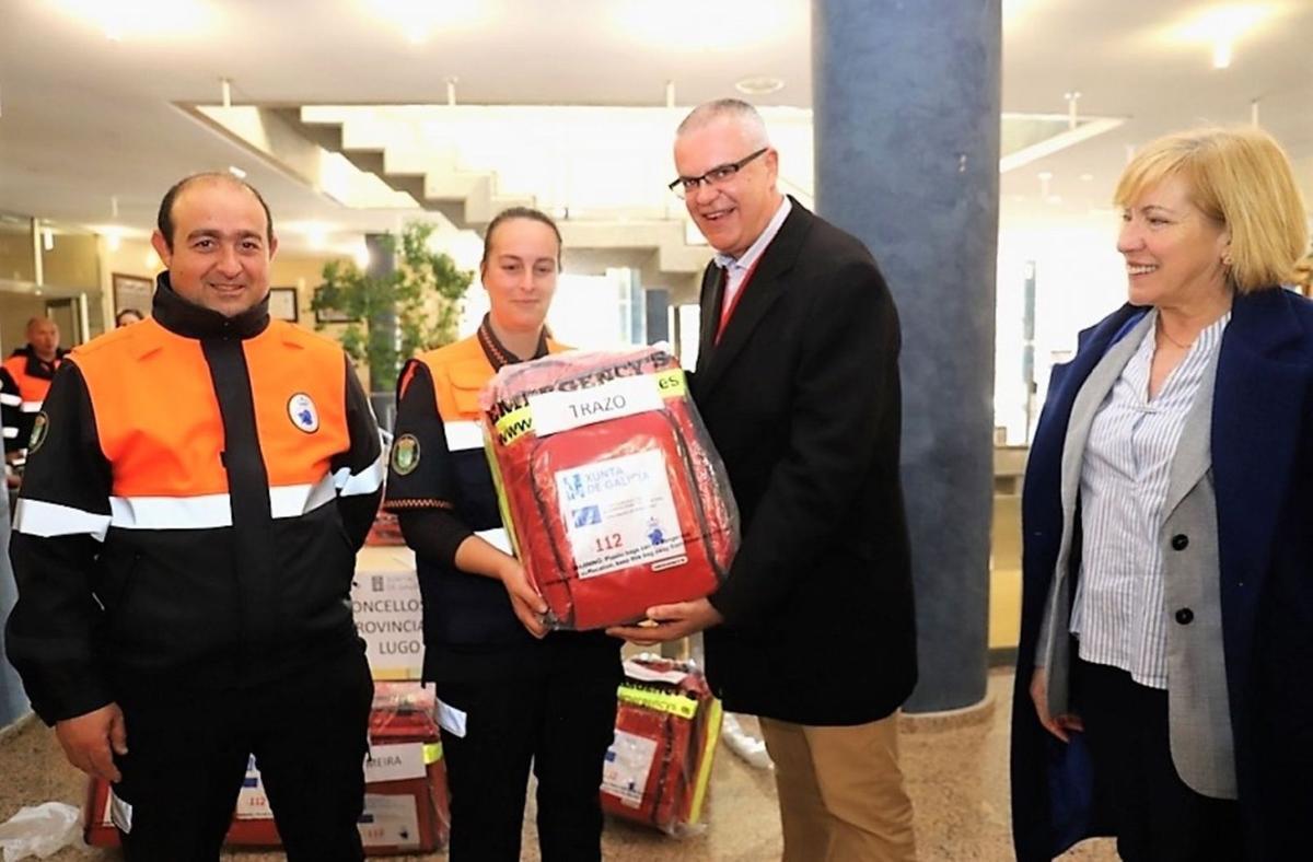 Miembros de la AVPC de Trazo, Óscar Noya, izqda. y Noelia Martínez, reciben un desfibrilador del director de Emerxencias ante su regidora