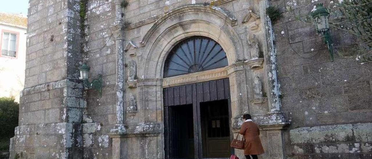 Una feligresa entrando en la iglesia de Santiago de Carril, ayer. // Noé Parga