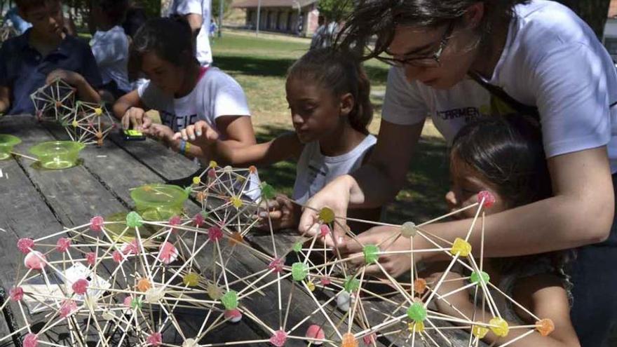 Carmen, arquitecta, enseña a las niñas cómo elaborar las estructuras usando palillos y gominolas.