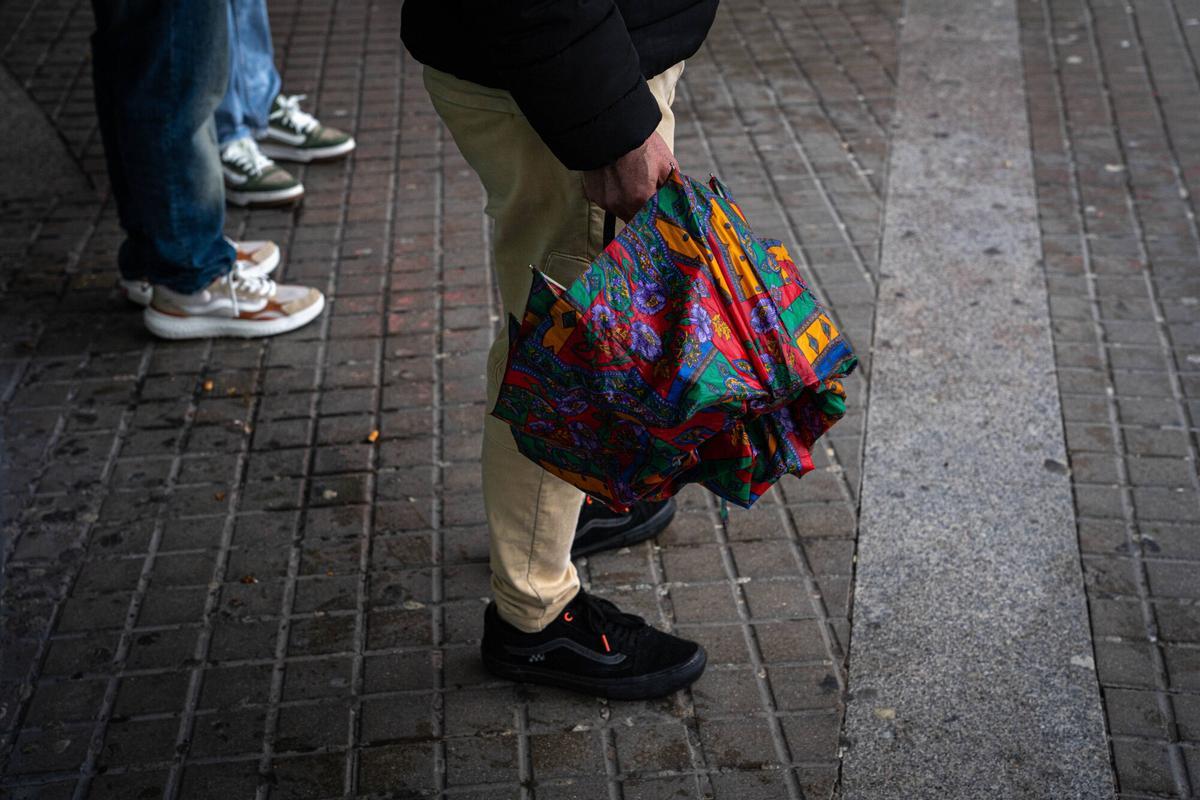 Gente con paraguas y chubasqueros por las lluvias.