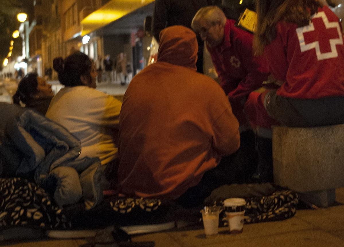 Voluntarios de Cruz Roja hablan con varias personas sin hogar en el bulevar del Gran Capitán.