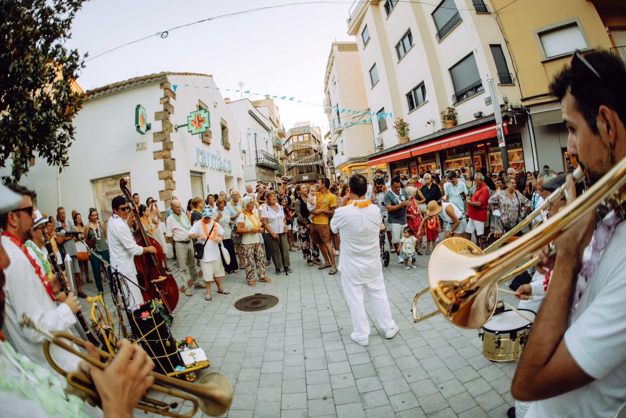 La música llatinoamericana i la cobla de Coblatròpic converteixen el nucli antic de Palamós en una pista de ball improvisada.