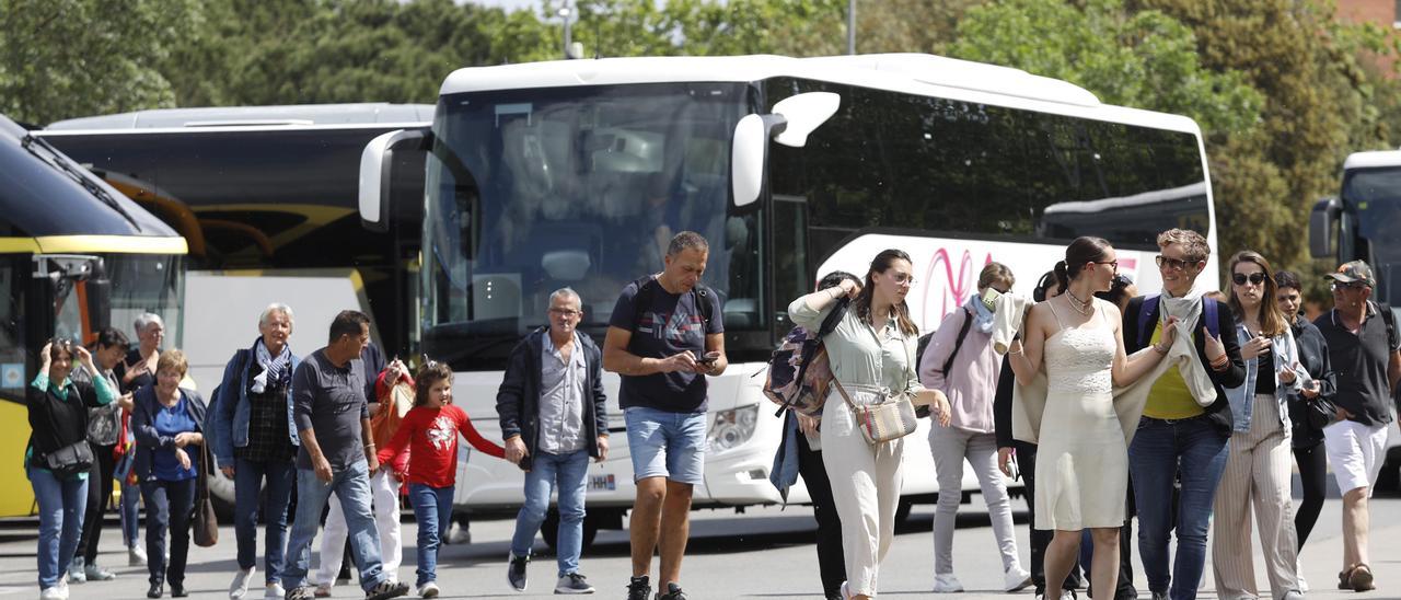 Visitants a la mostra amb els autobusos al fons.