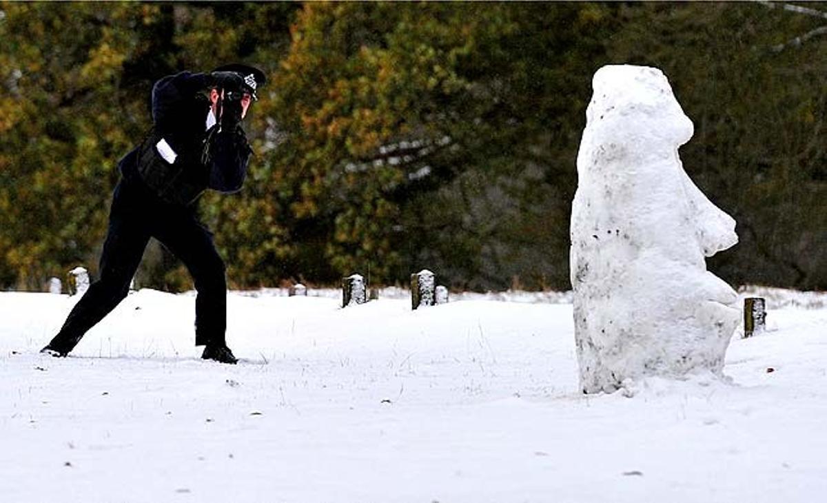 Un oficial de Policia fa fotografies d’un ninot de neu al parc de Richmond, al sud-oest de Londres (Regne Unit). La neu i les baixes temperatures segueixen afectant les carreteres, el ferrocarril i els serveis aeris del país.