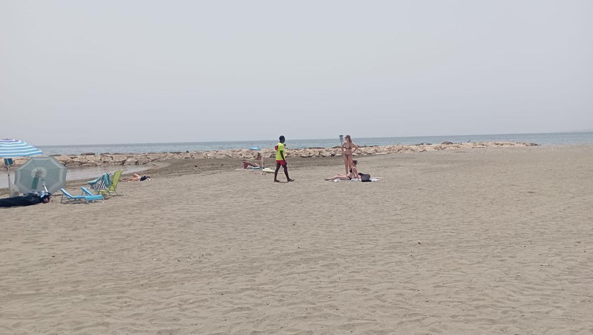 Un socorrista advierte a dos bañistas del riesgo de bañarse en las playas de Pedregalejo por la presencia de la bacteria E.coli.