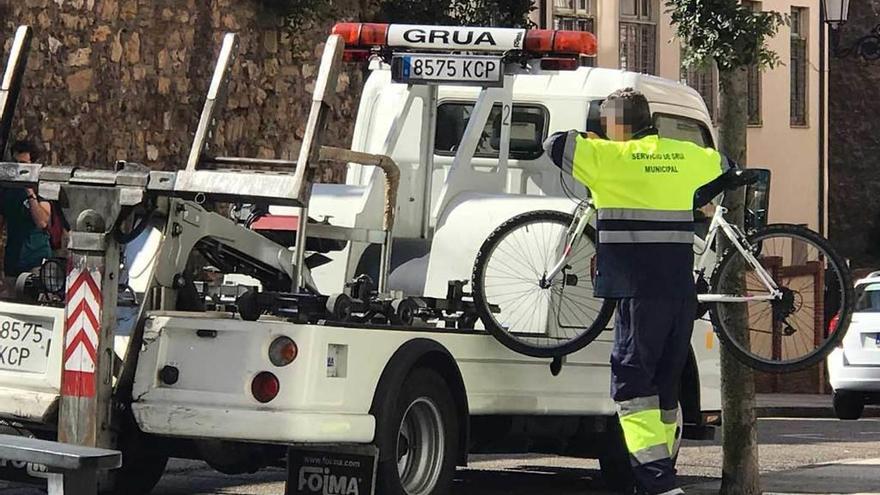 La grúa, llevándose la bicicleta aparcada en el barrio de Santo Domingo.