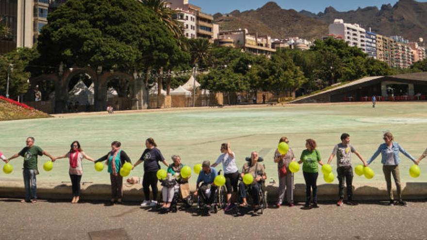 Miembros de la Asociación tinerfeña de Esclerosis Múltiple forman una cadena humana solidaria.