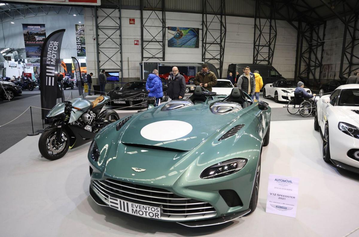 Asistentes al salón observando los Aston Martin expuestos.