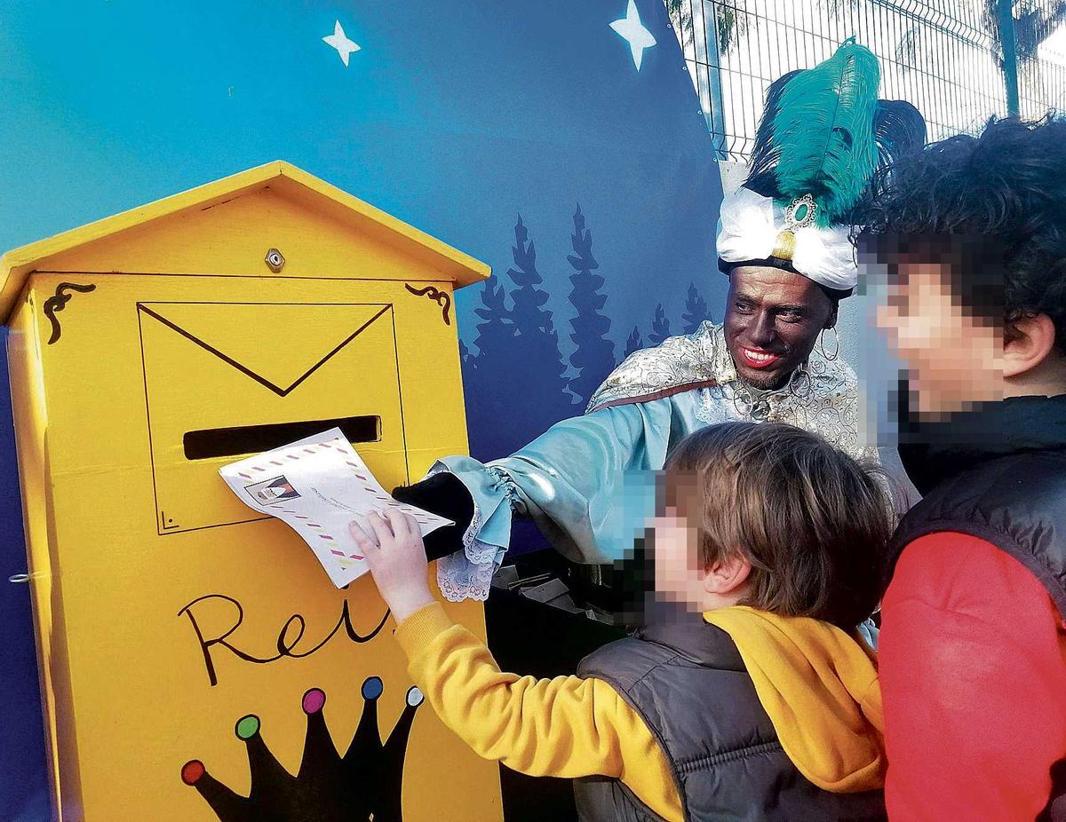 Balthasars Helfer zeigt einem Kind in Capdepera, wo der Wunschzettel eingeworfen werden muss.