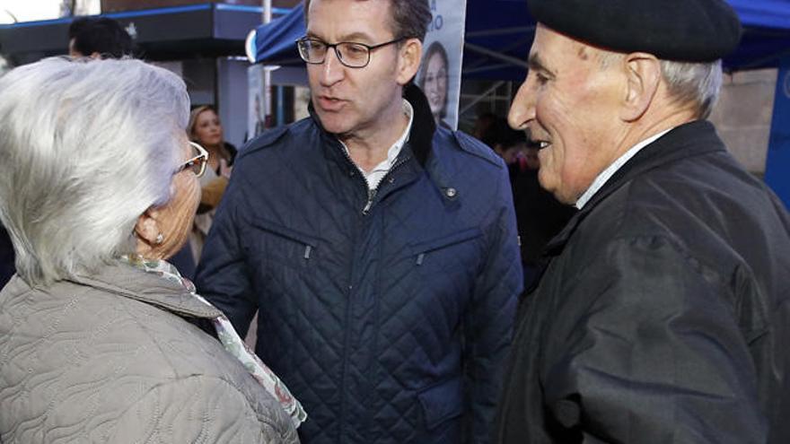 Feijóo charla con dos personas en un paseo por Príncipe, la pasada campaña electoral. // Marta G. Brea