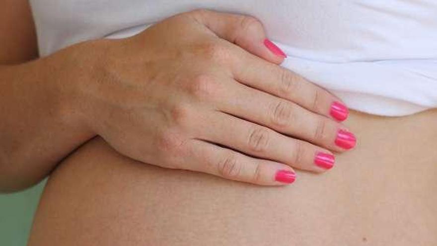 Una mujer embarazada muestra su barriga. / la opinión