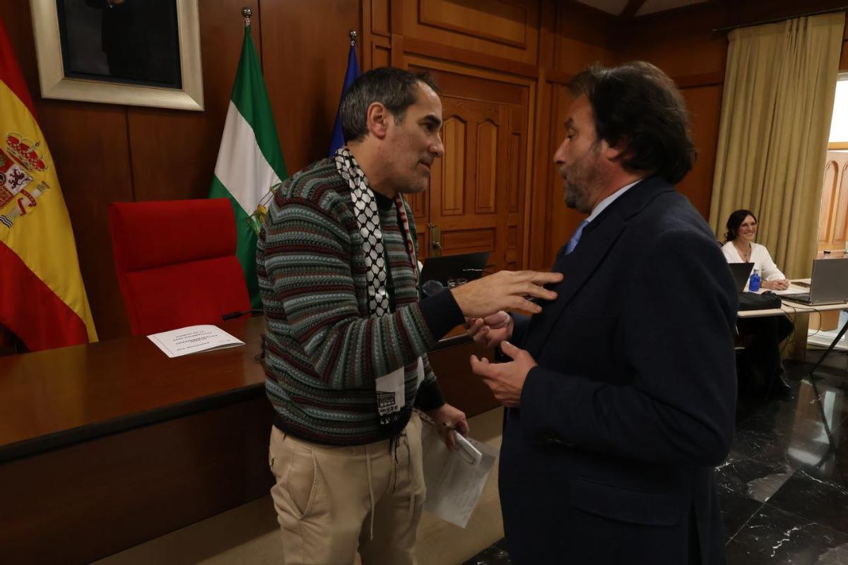 Juan Hidalgo (i), de Hacemos Córdoba, conversa con Daniel García-Ibarrola (d), concejal del PP, este jueves en el pleno municipal.