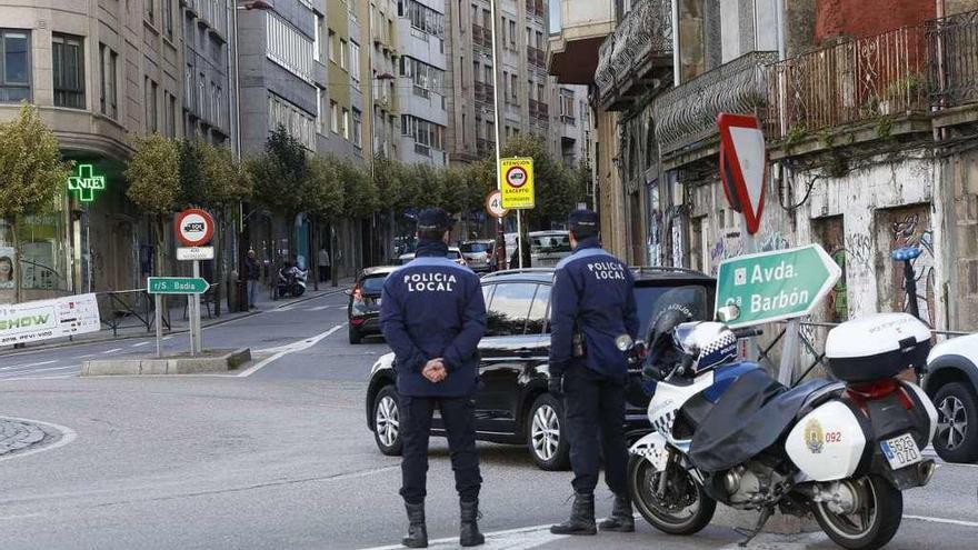 Dos agentes de la Policía Local vigilan el acceso de vehículos a Sanjurjo Badía esta semana. // R. Grobas