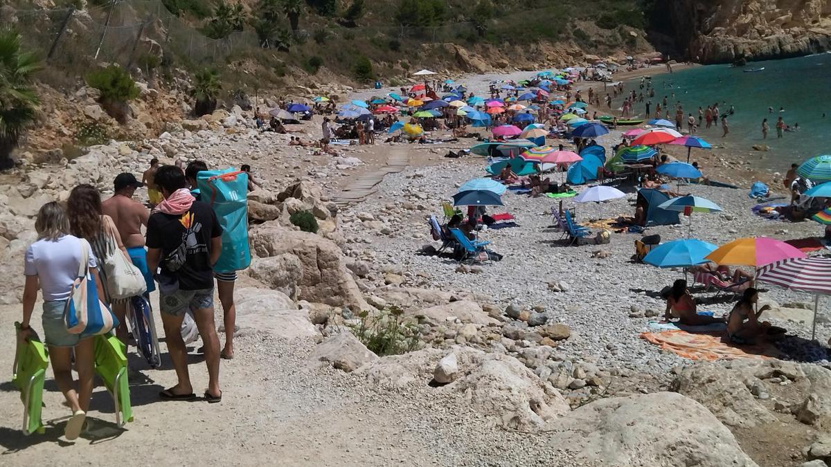 Un grupo de bañistas llega a la cala del Moraig