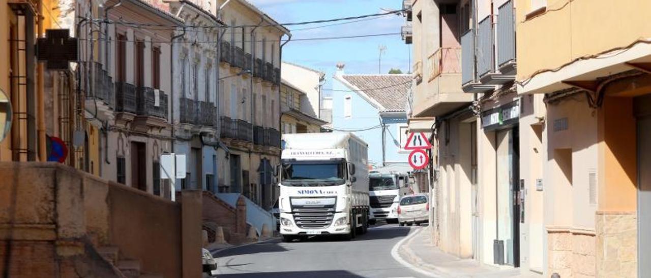 Camiones por el casco urbano de Pedralba, el tráfico rodado que pretende sacar del centro la variante que cirularía por el sur.  | PACO CALABUIG