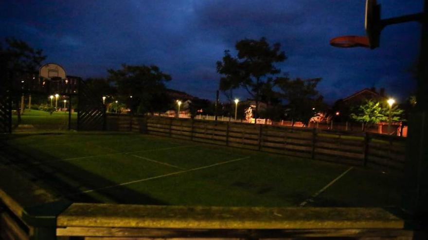 Pista deportiva en la zona de juegos del parque La Deva de Salinas, al anochecer, casi sin luz.
