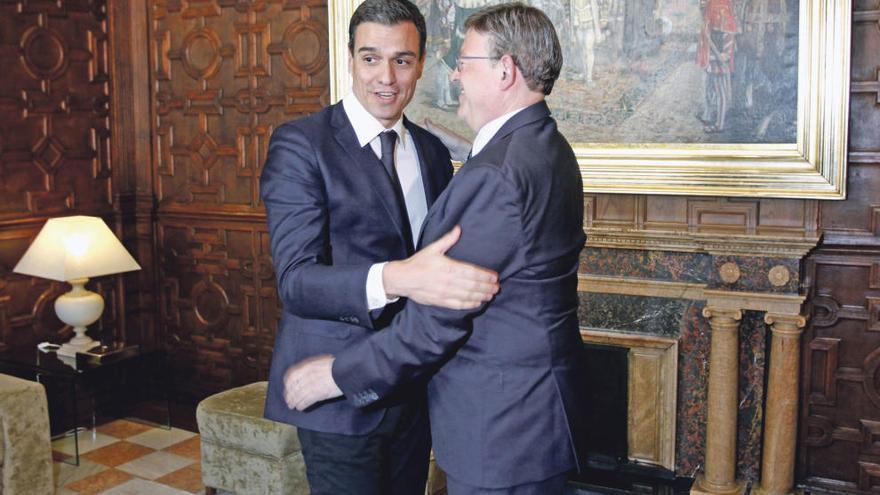 Pedro Sánchez abraza a Ximo Puig en su primera visita al Palau de la Generalitat.